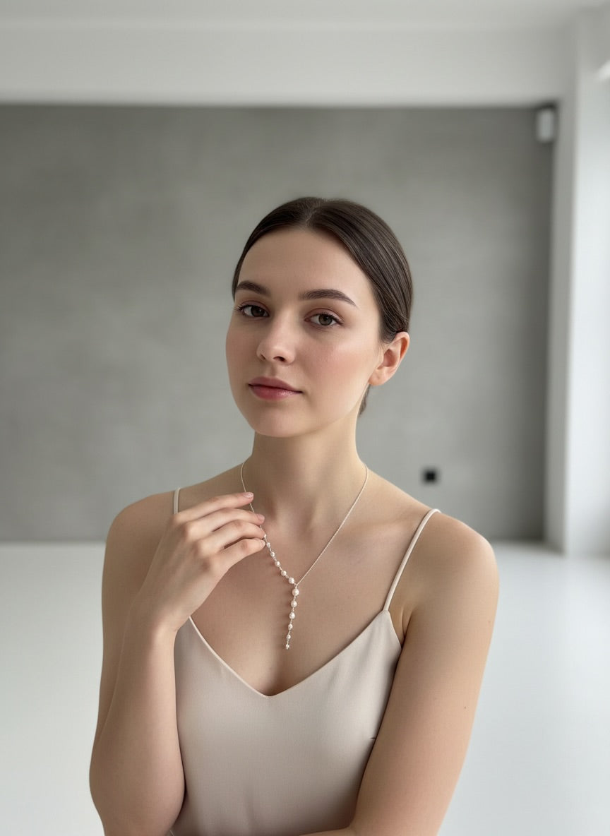Modern bride wearing a delicate freshwater pearl Y necklace with a soft cascading drop design